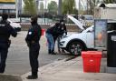 Police search a car at a petrol station after a shooting in Trappes, outside Paris (Emma Da Silva/AP)