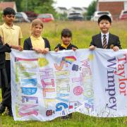 The children from Primary 5 at St Mark’s Primary in Barrhead with the 
winning flag for Taylor Wimpey West Scotland’s Springhill Gardens development.