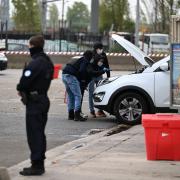 Police search a car at a petrol station after a shooting in Trappes, outside Paris (Emma Da Silva/AP)